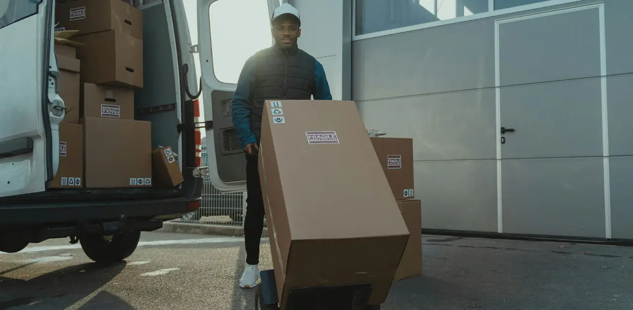 A Man Efficiently Loading Boxes Into A Van, Ready For A Delivery