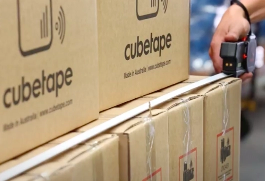 A Person Grasping A Box Secured With Tape, Indicating Packaging For Shipment